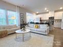 Open concept living room with cozy white furniture, light-filled windows, and seamless flow to kitchen at 314 Olympia Way, York, SC 29745