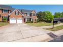 Beautiful brick home with a two-car garage, manicured lawn, and mature trees at 320 Falesco Ln, Matthews, NC 28105