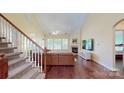 Bright living room with hardwood floors, fireplace, and staircase access at 320 Falesco Ln, Matthews, NC 28105
