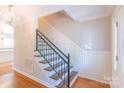 Elegant staircase featuring wood steps and a wrought iron railing, showcasing the home's interior at 3921 Bon Rea Dr, Charlotte, NC 28226