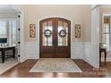 Elegant foyer with double doors, hardwood floors, decorative rug, and wainscoting detail at 400 Eden Hollow Ln, Weddington, NC 28104
