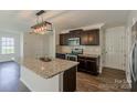 Kitchen with stainless steel appliances, granite countertops, a kitchen island, and dark wood cabinets at 4200 Long Arrow Dr, Concord, NC 28025