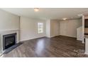 Spacious living room with fireplace, hardwood floors, and a bright window with natural light at 4200 Long Arrow Dr, Concord, NC 28025
