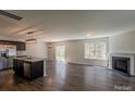Open-concept living room features a fireplace, hardwood floors, and stainless steel appliances in the kitchen at 4200 Long Arrow Dr, Concord, NC 28025
