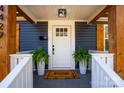 Stylish front porch with a welcome mat, potted plants, and wooden accents on the doorframe at 4429 Major St, Charlotte, NC 28208