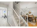 Carpeted stairs with white railing leading to the second floor with dining area nearby at 5549 Lemley Nw Rd, Concord, NC 28027