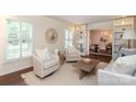 Bright living room with neutral-toned furniture, large windows with shutters, and decorative shelving at 6036 Sharon Acres Rd, Charlotte, NC 28210