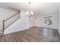Open living room with wood-look floors, large window, and modern chandelier at 609 Sweet Bonnie Ln, Belmont, NC 28012