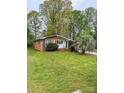 Charming brick home with a lush front lawn and mature trees at 6115 Amberly Ln, Charlotte, NC 28213