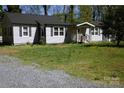 Traditional single-story home with a well-manicured lawn and a charming front porch for relaxation at 6124 Old Plank Rd, Charlotte, NC 28216