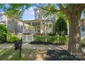 Two-story home with a cozy front porch, framed by a lush green tree at 6165 Caseys Side Way, Fort Mill, SC 29708