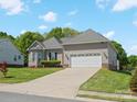 Side view of home with a well-kept lawn and a two-car garage featuring a long driveway at 621 Summey Farm Dr, Dallas, NC 28034
