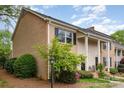 Charming townhome exterior showcasing brick and siding, manicured landscaping, and inviting covered entrances for each unit at 6801 Dumbarton Dr, Charlotte, NC 28210