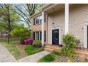 Charming two-story townhome featuring a brick facade, black shutters, and a well-maintained front yard with flowering bushes at 6801 Dumbarton Dr, Charlotte, NC 28210