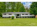 Charming home with a manicured lawn and a neatly trimmed hedge row at 7048 Delta Lake Dr, Charlotte, NC 28215