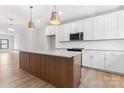 Bright kitchen features a large island, modern appliances, and sleek white cabinetry at 710 Falling Oak Aly # 17, Huntersville, NC 28078