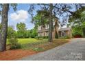 Quaint brick home with mature trees, and a gravel driveway, providing a private and secluded feel at 819 Old Dutch W Rd, Indian Trail, NC 28079