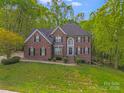 Beautiful two-story brick home with lush landscaping and a welcoming front entrance at 1000 Potters Bluff Rd, Monroe, NC 28110