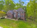 Beautiful two-story brick home with lush landscaping and a welcoming front entrance at 1000 Potters Bluff Rd, Monroe, NC 28110