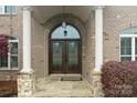 Elegant entryway with arched double doors, stone accents and grand columns at 1012 Harper Lee Dr, Newton, NC 28658