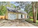 Charming cream colored home with a well-maintained lawn and attached garage, shaded by mature trees at 10432 Camelback Cir, Charlotte, NC 28226