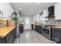 Modern kitchen featuring two-tone cabinets, wood countertops, stylish backsplash, and stainless steel appliances at 110 Shamrock Ne St, Concord, NC 28025
