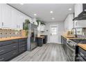 Modern kitchen featuring two-tone cabinets, wood countertops, stylish backsplash, and stainless steel appliances at 110 Shamrock Ne St, Concord, NC 28025