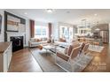 Open-concept living space with hardwood floors, modern decor, a cozy fireplace, and dining area at 124 Fordham Ct # 19, Fort Mill, SC 29715