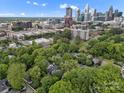 Stunning aerial view showcasing a home nestled among lush greenery, with the city skyline in the background at 1514 S Rensselaer Pl, Charlotte, NC 28203