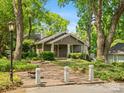 Charming home exterior featuring a brick driveway, mature trees, and a cozy front porch at 1514 S Rensselaer Pl, Charlotte, NC 28203