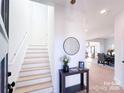 Bright entryway with stairs, a table with decor, and an open view to the dining and kitchen areas at 1525 Solitude Ct, Kannapolis, NC 28081