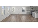 Open-concept living room showcases hardwood floors and large windows to let in natural light at 15910 Parkside Crossing Dr # 318, Charlotte, NC 28278
