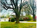 View of the home and detached garage with large trees around the property at 215 E K St, Newton, NC 28658