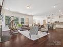 Spacious living room with dark hardwood floors, neutral furniture, and large windows offering ample natural light at 2751 Collaroy Rd, Waxhaw, NC 28173