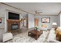 Cozy living room featuring a brick fireplace, ceiling fan, and a comfortable seating area at 5110 Old Still Ln, Bessemer City, NC 28016