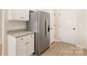 Bright kitchen featuring granite counters, stainless steel refrigerator, and white cabinets at 5711 Skinny Down, Charlotte, NC 28215