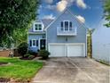 Charming two-story home with light blue siding, a balcony, black shutters, and a two-car garage at 6013 Coaching Inn Ct, Charlotte, NC 28270