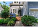 Inviting home entrance featuring a landscaped garden and a classic front door, with sidelight and hanging light at 6013 Coaching Inn Ct, Charlotte, NC 28270