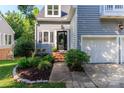 Charming home featuring a landscaped garden and a classic front door with sidelight and second-floor balcony at 6013 Coaching Inn Ct, Charlotte, NC 28270