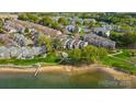 Scenic aerial view of lakeside condos featuring lush landscaping and private beach access for residents to enjoy at 7836 Village Harbor Dr, Cornelius, NC 28031