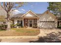 Charming single-story home with brick and white siding, attached garage, and well-manicured lawn at 8603 Bookwalter Ct, Charlotte, NC 28277