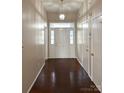 Inviting hallway with hardwood floors, a stylish light fixture, and a front door with decorative glass panels at 10400 Brawley Ln # 8, Charlotte, NC 28215