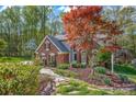 Brick home with lush landscaping and a stone pathway at 125 Cove Creek Loop # 18, Mooresville, NC 28117