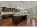 Open kitchen with a large island, granite countertops, dark cabinets, and stainless steel appliances at 13311 Union Square Dr, Huntersville, NC 28078
