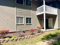 Charming condo with a white balcony, a small garden bed with vibrant flowers, and grassy area at 140 Lake Concord Ne Rd # D-1, Concord, NC 28025