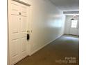 Well-maintained hallway with neutral carpet, an exit door, and a front door labeled 'D1' at 140 Lake Concord Ne Rd # D-1, Concord, NC 28025