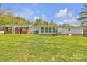 Spacious backyard featuring a well-maintained lawn, a covered patio and a single-story home with brick accents at 1975 Old Wilkesboro Rd, Taylorsville, NC 28681
