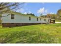 The house has a well-maintained lawn and multiple windows that provide ample natural light into the home at 1975 Old Wilkesboro Rd, Taylorsville, NC 28681