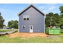 Rear exterior view of the blue siding, showcasing a door and a green dumpster at 2628 S Main St, Kannapolis, NC 28027