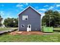 Rear exterior view of a two-story home featuring blue siding and a verdant lawn on a clear, sunny day at 2628 S Main St, Kannapolis, NC 28027